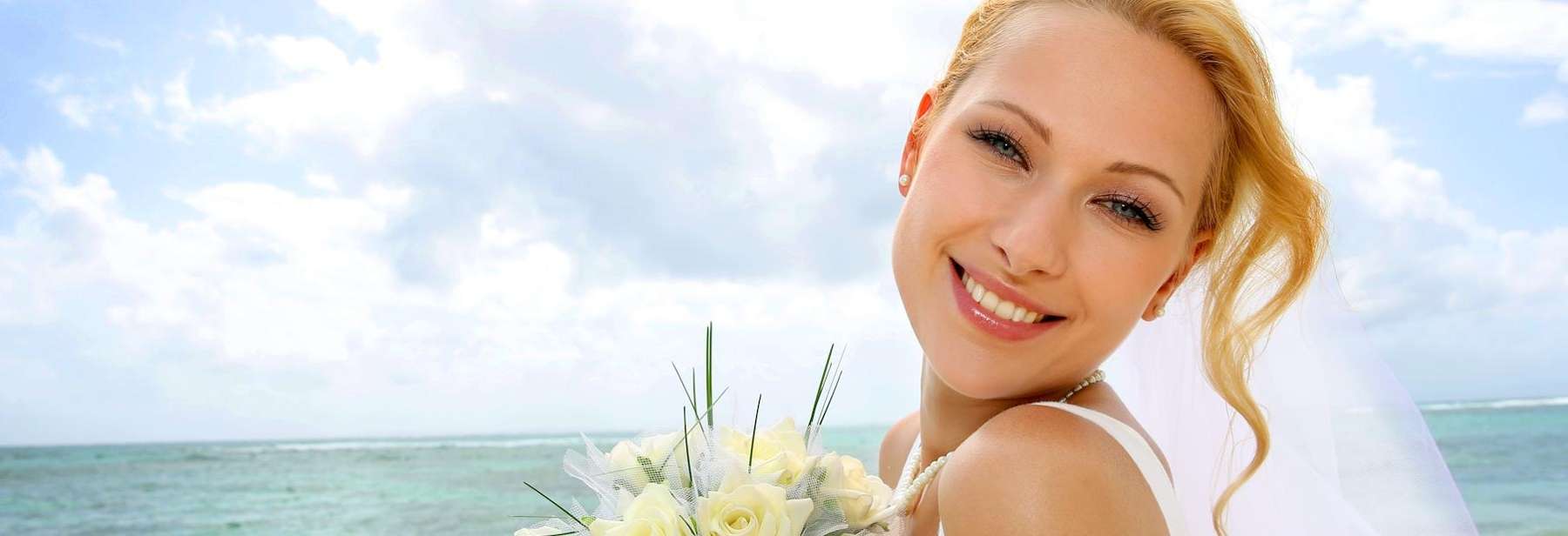 Blonde bride by the ocean smiling, fishers in
